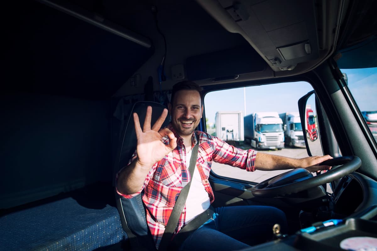 Smiling lorry driver waving from his cab